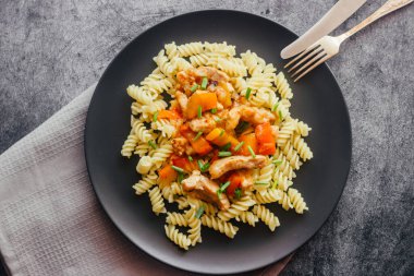 Tatlı ve ekşi soslu domuz eti ve makarna. Tabakta nefis bir sıcak yemek. Biberli domuz eti ve yeşil soğan.
