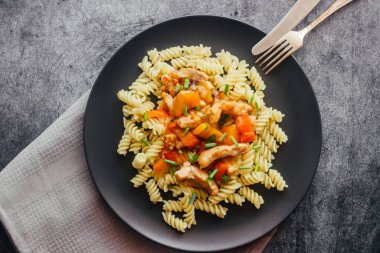 Tatlı ve ekşi soslu domuz eti ve makarna. Tabakta nefis bir sıcak yemek. Biberli domuz eti ve yeşil soğan.