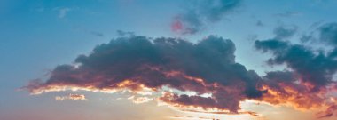 Gökyüzündeki renkli bulutlar batan güneşin ışınları tarafından vurgulanıyor..