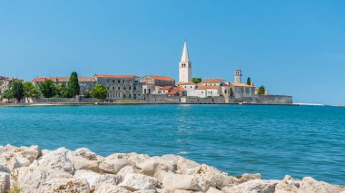Hırvatistan 'ın kıyı kenti Porec, güneşli bir günde deniz kenarındaki gezinti alanından manzara.