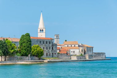 Hırvatistan 'ın kıyı kenti Porec, güneşli bir günde deniz kenarındaki gezinti alanından manzara.