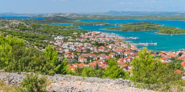 Hırvatistan 'ın Murter kıyı kenti, güneşli bir yaz gününde Raduc Dağı' nın tepesinden görülen küçük adalar ve dağlık bir manzarayla deniz kıyısında yer alıyor..