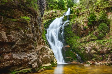 Dev Dağlar, Kamienczyk Şelalesi, Batı Sudetleri 'nin en yükseği, akarsuyun berrak suları kayaların üzerinden akar. Güneşli bir yaz gününde uzun pozlama.