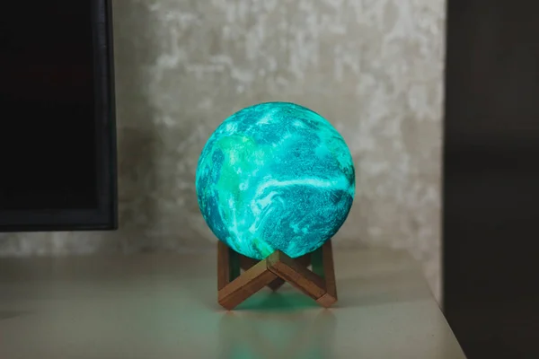 planet or moon lamp stands on the table. round night light