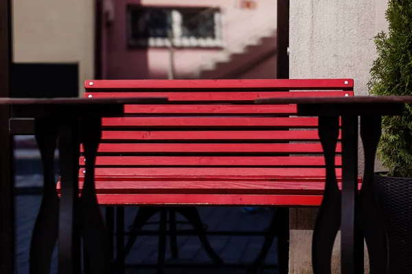 an empty red cafe bench with tables without people. outdoor summer terrace