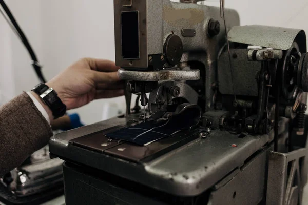 man on sewing machine and item of clothing, old sewing machine,vintage style