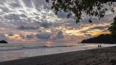 Güzel tropikal altın gün batımı zaman çizelgesi kıyıdan görülüyor. Altın ve kırmızı tropikal şafak 4k video 