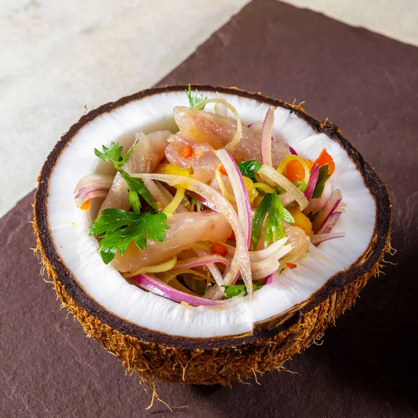Ceviche dish - appetiser of fresh fish marinated in citrus with tropical fruits served in a Coconut Bowls.