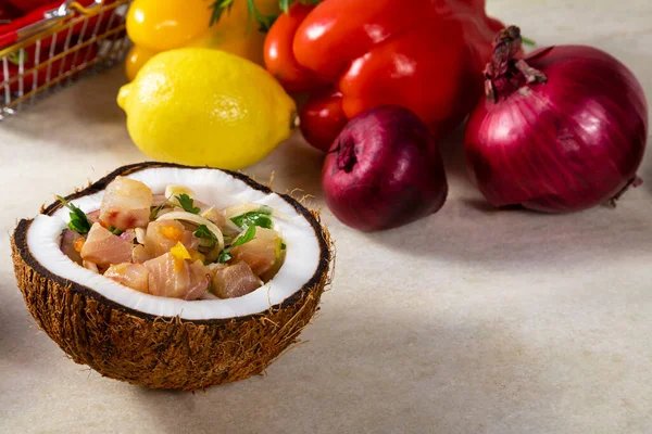 Ceviche dish - appetiser of fresh fish marinated in citrus with tropical fruits served in a Coconut Bowls.
