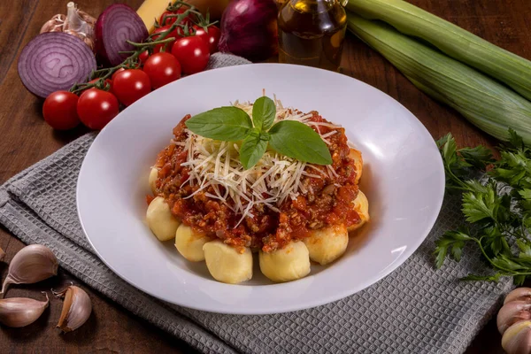 Doğal organik domates soslu bolonez gnocchi, böcek ilacı yok, rendelenmiş parmesan peyniri ve fesleğen yapraklı.