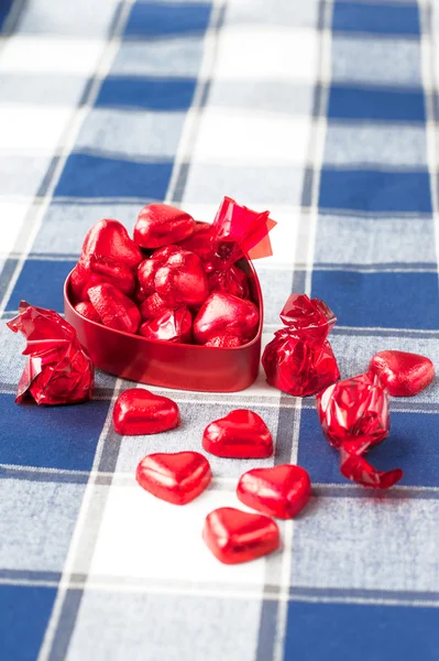 Chocolats sucrés en forme de coeur dans une boîte en métal rouge. Gros plan . — Photo