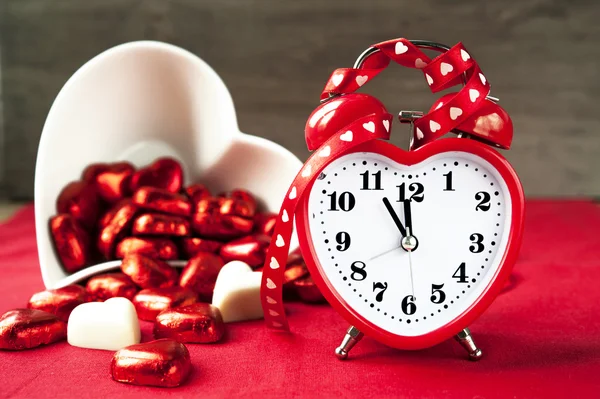 Horloge d'amour rouge en forme de coeur Saint-Valentin avec chocolats sucrés — Photo