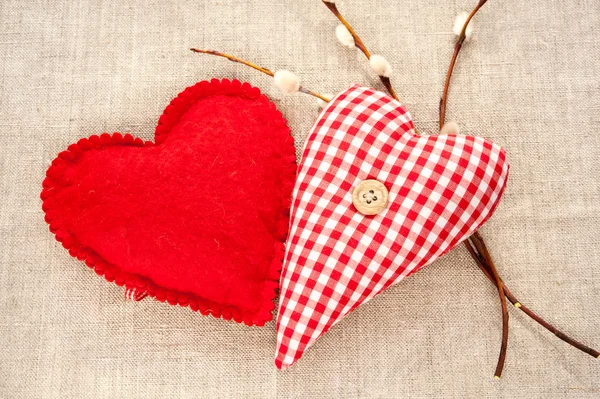 Twee zelfgemaakte naaide rode katoen liefde harten met veer willow twi — Stockfoto