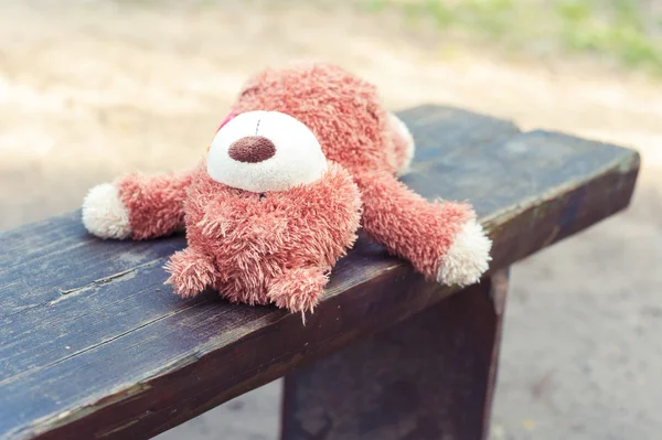 Abandoned on the wooden bench lonely teddy bear toy — Stock Photo, Image