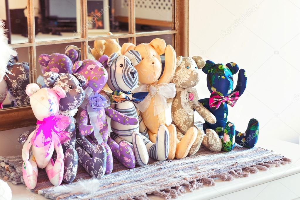 Many textile tilda teddy bear toys in workshop.