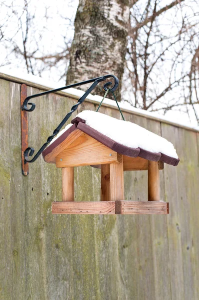 Alimentador de aves colgantes cubierto de nieve en invierno . — Foto de Stock