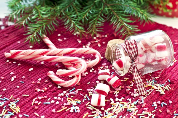 Sweet candies poured from glass jar. Green fir christmas — Stock Photo, Image