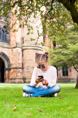Cep telefonu Glasgow Üniversitesi garde içinde oturan genç bir bayanla