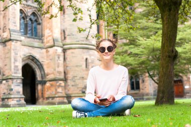 Cep telefonu Glasgow Üniversitesi garde içinde oturan genç bir bayanla