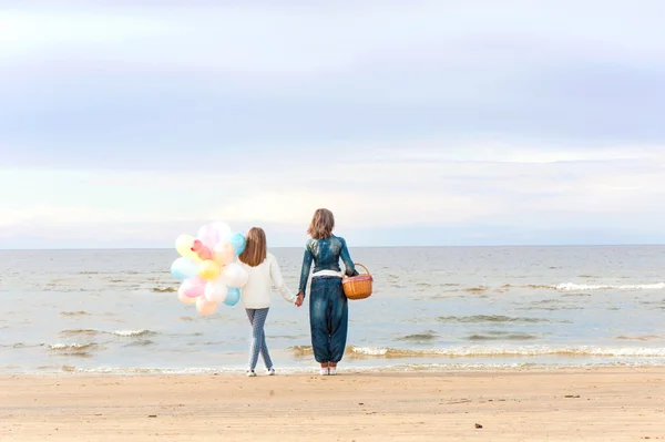 Mother and daughter together holding hands and contemplating sea — Stock Photo, Image