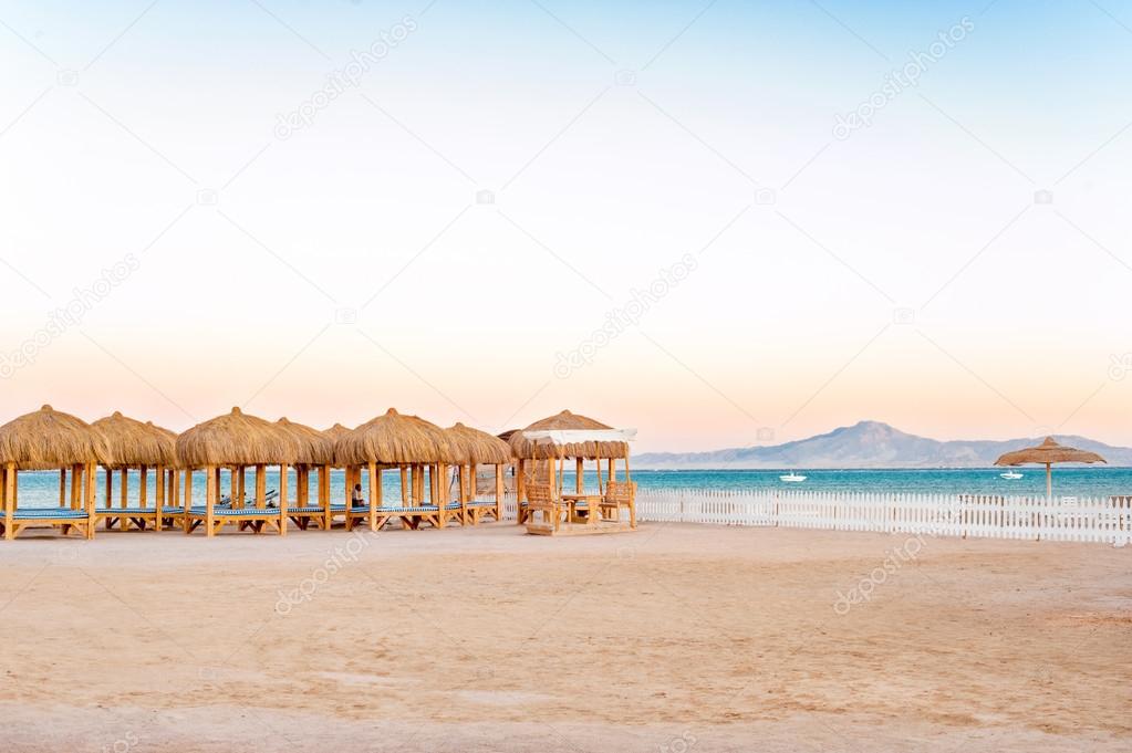 Wooden beach houses with straw roof on the egyptian seaside.