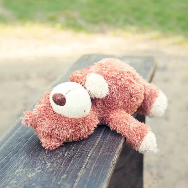 Lonely forgotten teddy bear toy lying on the bench. — Stock Photo, Image