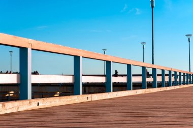 Wooden quayside in rays of evening sunlight.