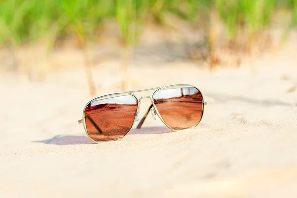 Lunettes de soleil tendance perdues sur la plage de sable. Multicolore à l'extérieur — Photo