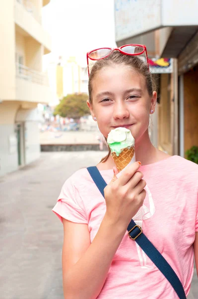 Happy smiling young girl eating green mint ice-cream. — Stok fotoğraf