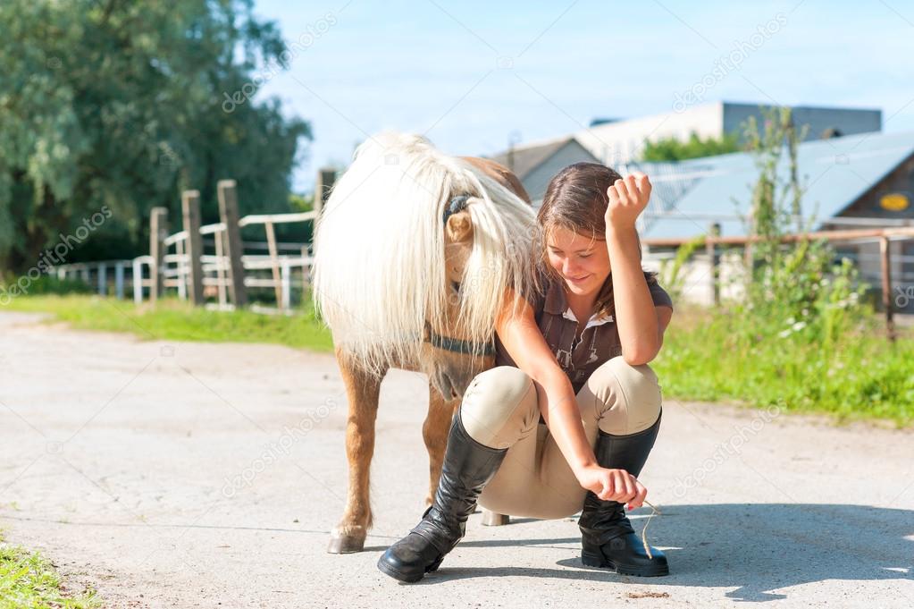 Lets play! Teenage cheerful girl with playful shetland pony.