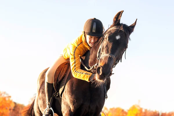 Teenage girl equestrian hugging her horse. Vibrant summertime ou — Stock Photo, Image