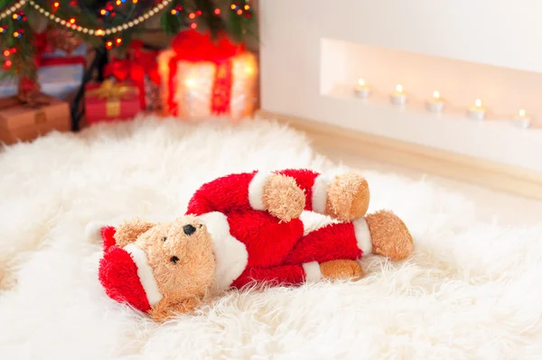 Weihnachtsmann-Teddybär-Spielzeug liegt auf Schaffell in der Nähe beleuchteter Weihnachten — Stockfoto