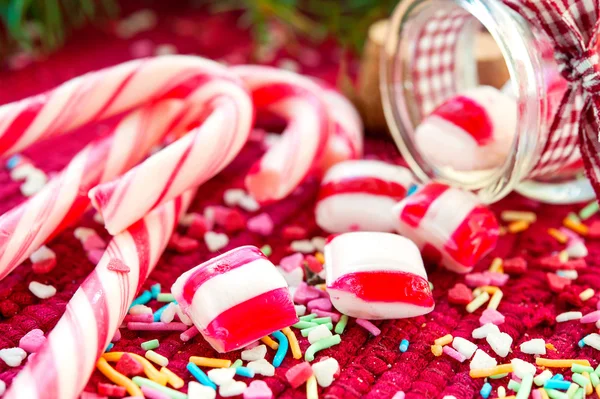 Sweet candies spilled/poured from glass jar on christmas backgro — Stock Photo, Image