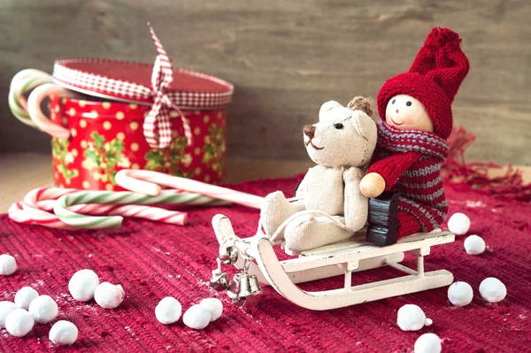 Christmas miniature toys on sledges and gift box with candies. — Stock Photo, Image