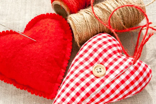 Dos textiles caseros cosidos corazones de amor de algodón rojo. Primer plano. . — Foto de Stock