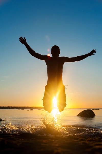 Summertime fun in the sea for joy. Jumping man silhouette. — Stock Photo, Image