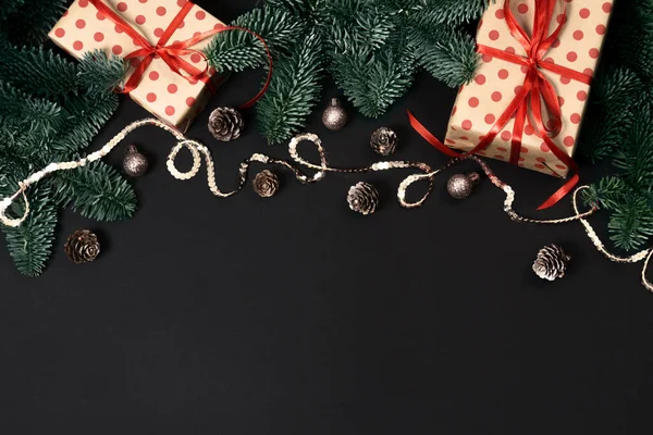 Yeni yıl kompozisyonu. Noel hediyeleri, kozalaklar, köknar dalları ve oyuncaklar. Düz konum, üst görünüm, kopyalama alanı.