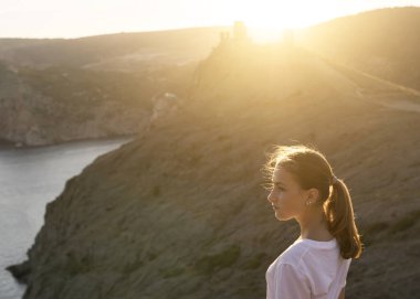Uzun saçlı, doğa ile eğlenen genç bir kızın güzel portresi. Güzel, sıcak güneş ışığı. Güzel genç kız. Yakın plan.