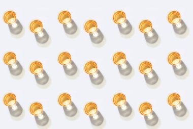 Beyaz zemin üzerinde portakal dilimleri olan birkaç bardak su.