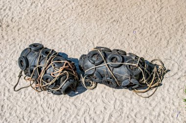 Siyah tekne şamandıraları kumda yatıyor. 