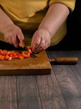 Tahtada sebze doğra. Kırmızı biber