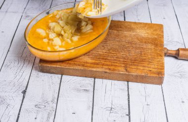 İspanyol omlet malzemeleri: beyaz ahşap arka planda yumurta, patates ve soğan..