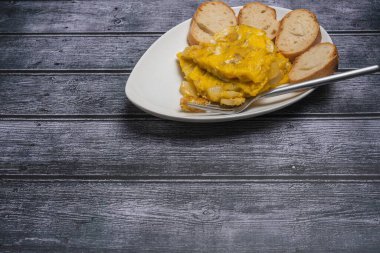 İspanyol omlet malzemeleri: koyu ahşap arka planda yumurta, patates ve soğan..