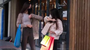 Yüz maskesi takan ve dirsek çarpmasıyla selamlaşan iki arkadaş. Coronavirüs salgını yeni normal.