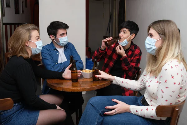 Empat Teman Memakai Masker Wajah Sebuah Pub Salah Satunya Adalah — Stok Foto