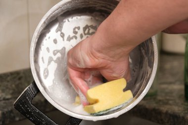 Bir adamın el yıkama ya da bulaşık yıkama görüntüsü. Ev işlerini temizliyorum..