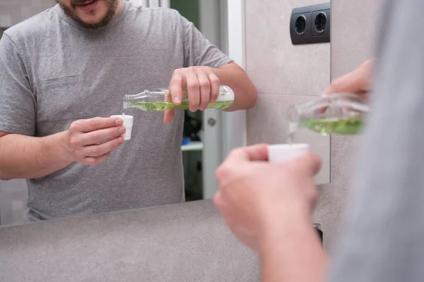 Man Giet Groen Mondwater Van Fles Dop Badkamer Tandverzorging Concept — Stockfoto