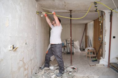 İnşaat alanında çalışan elektrik tamircisi. İş yerinde güvenlik.