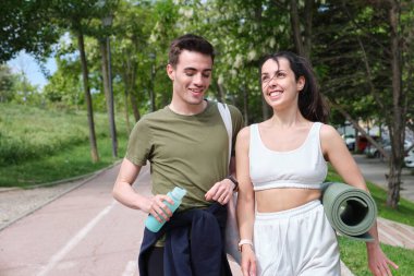 Genç spor çifti konuşuyor ve gülüyor. Fitness dışarıda.