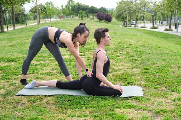 Personal Trainer Femminile Aiutare Giovane Parco Con Posa Piccione Yoga — Foto Stock